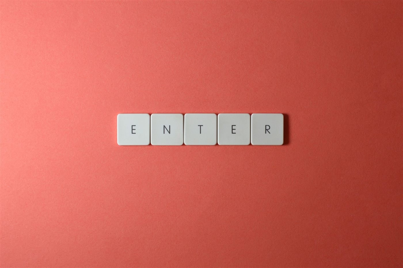 Keyboard keys spelling ENTER on a coral background